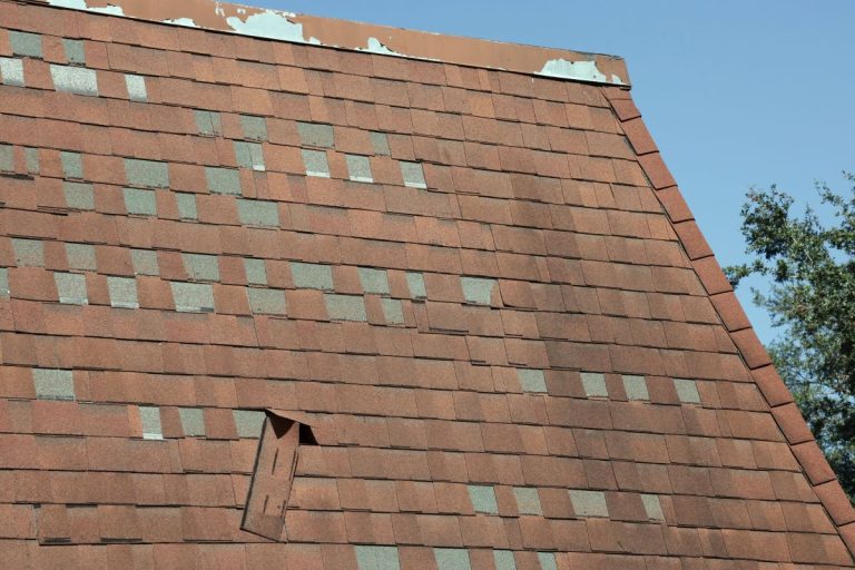 Multiple shingles are missing on the roof of a house in Woodbury