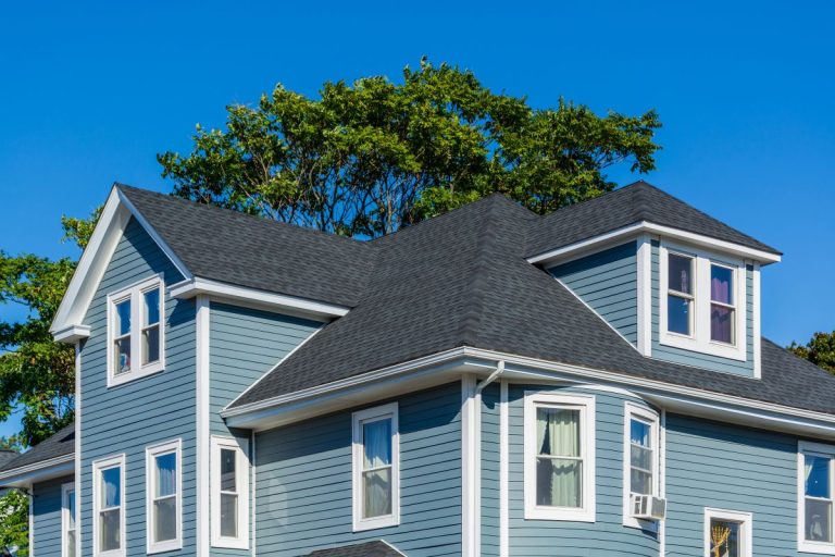 A blue house in Woodbury with grey asphalt shingles